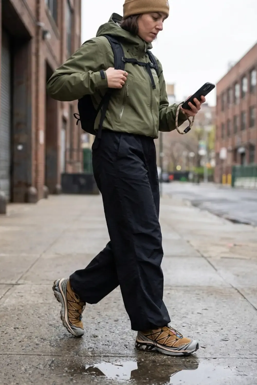A style-forward woman embodying the 'Gorpcore' movement, wearing a mix of high-performance gear and streetwear.