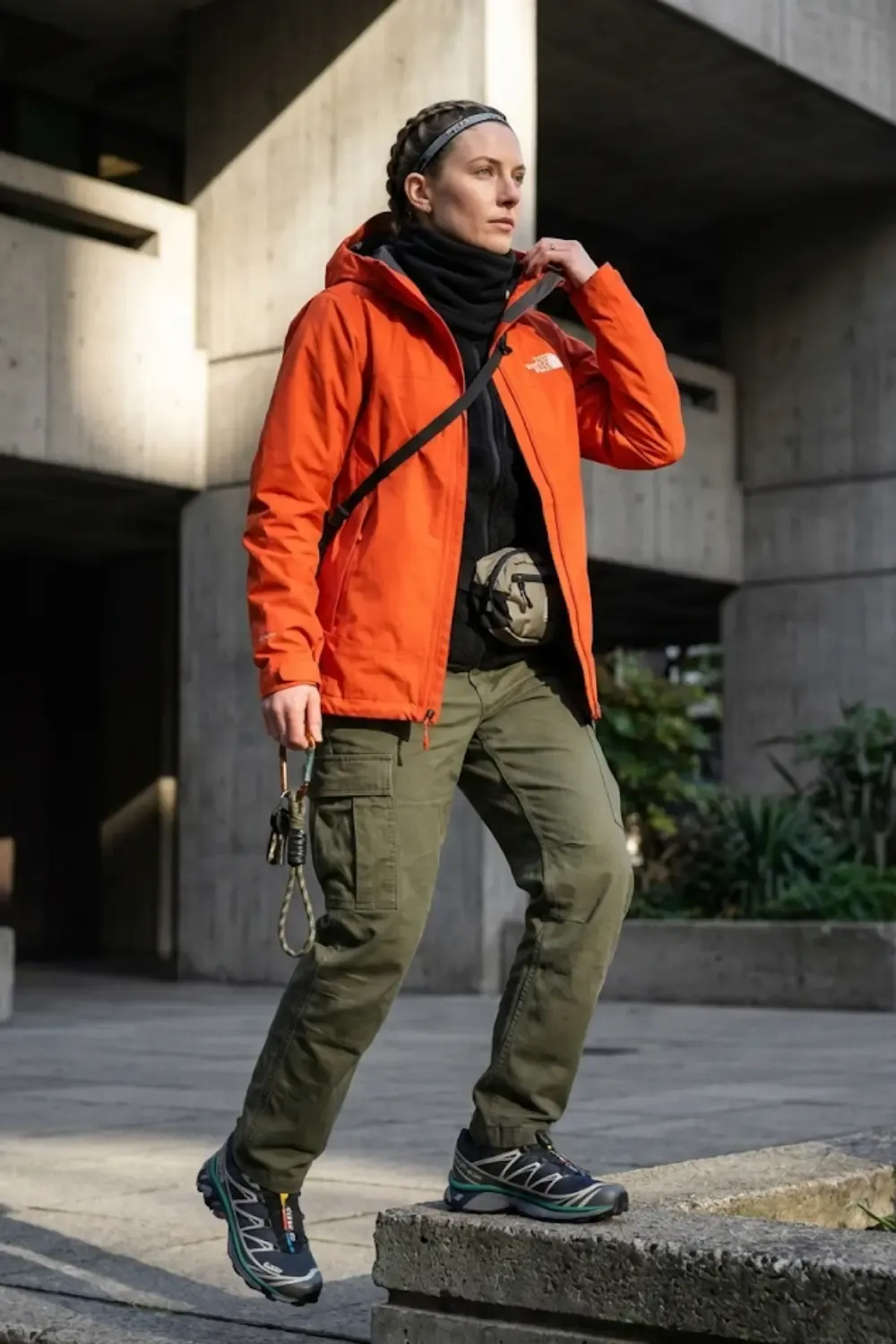 A woman epitomizing the 'Urban Hiking' aesthetic, blending high-performance mountain gear with city-ready styling.